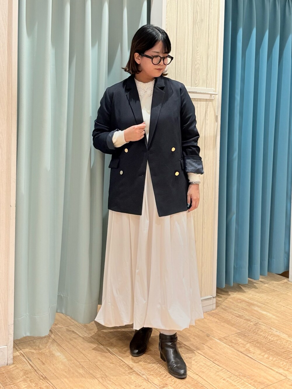 ブルー系のテーラードジャケット、ホワイト系のニット/セーターを着用したレディースの秋コーディネートの2枚目の写真