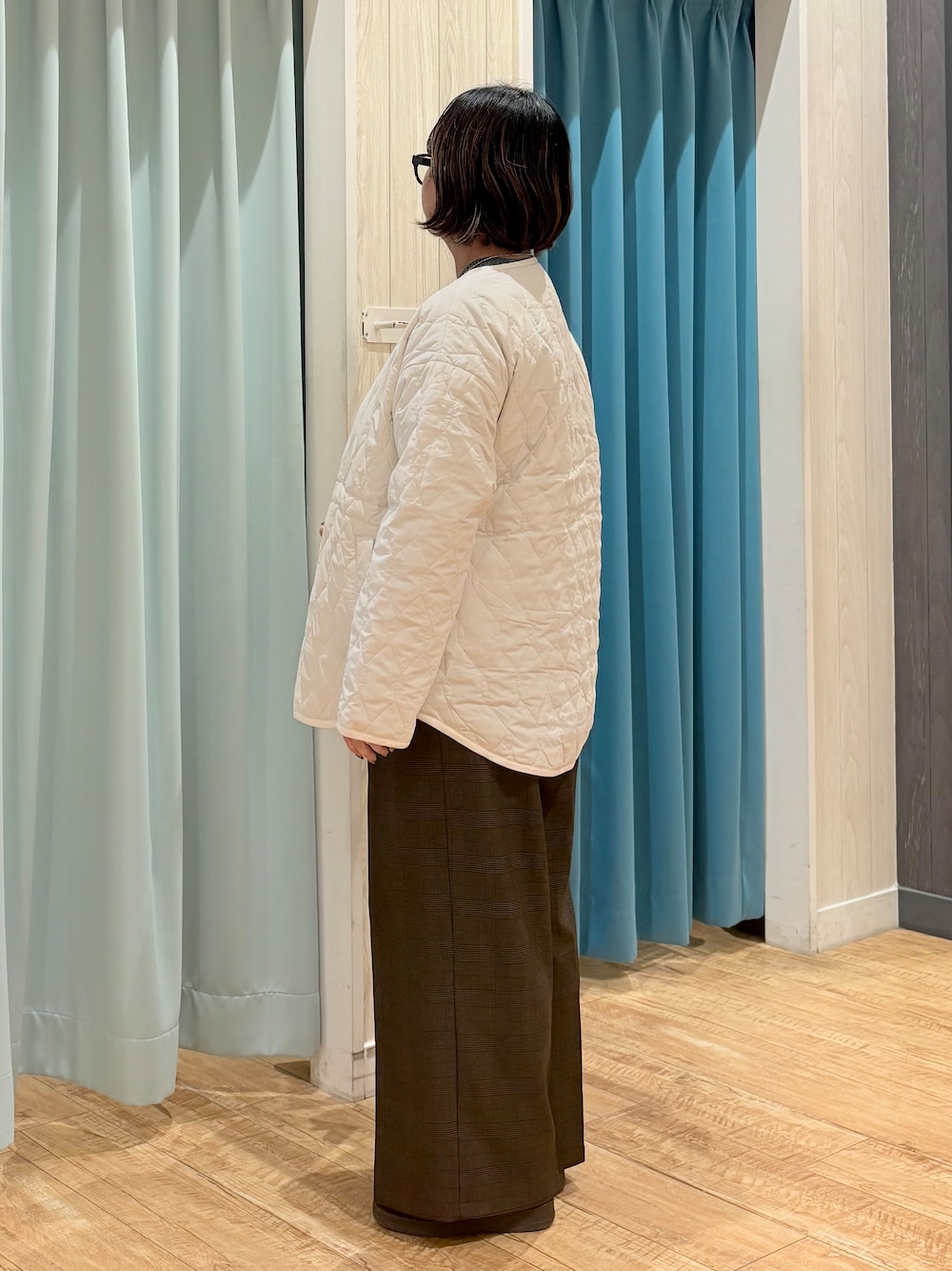 ホワイト系のノーカラージャケット、グレー系のニット/セーター、ブラウン系のその他パンツを着用したレディースの秋コーディネートの6枚目の写真