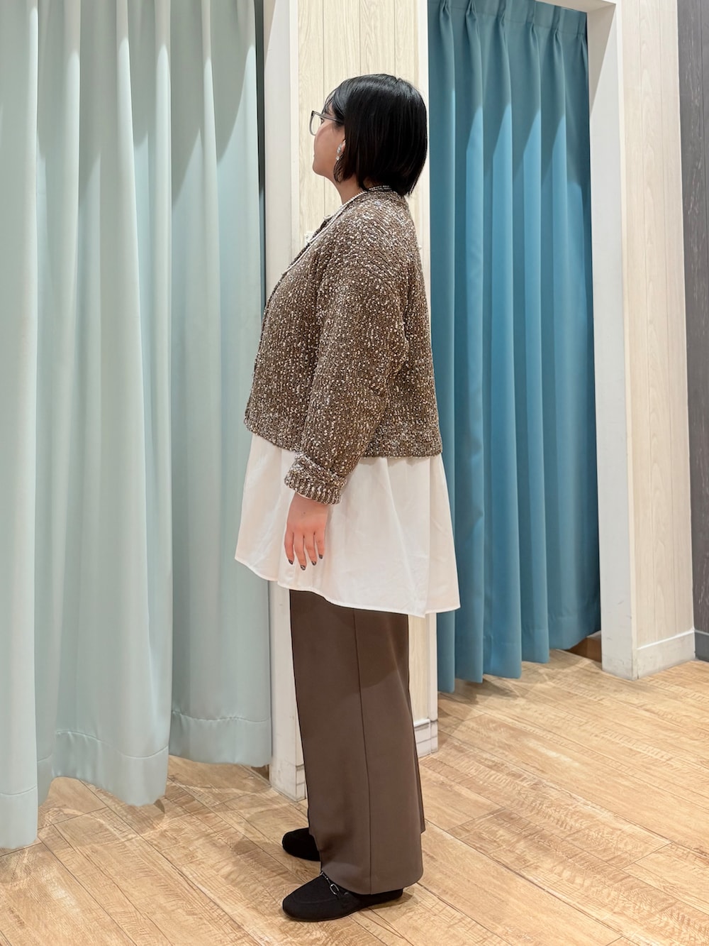 ブラウン系のカーディガン/ボレロ、ホワイト系のチュニック、ブラウン系のその他パンツを着用したレディースの春コーディネートの2枚目の写真