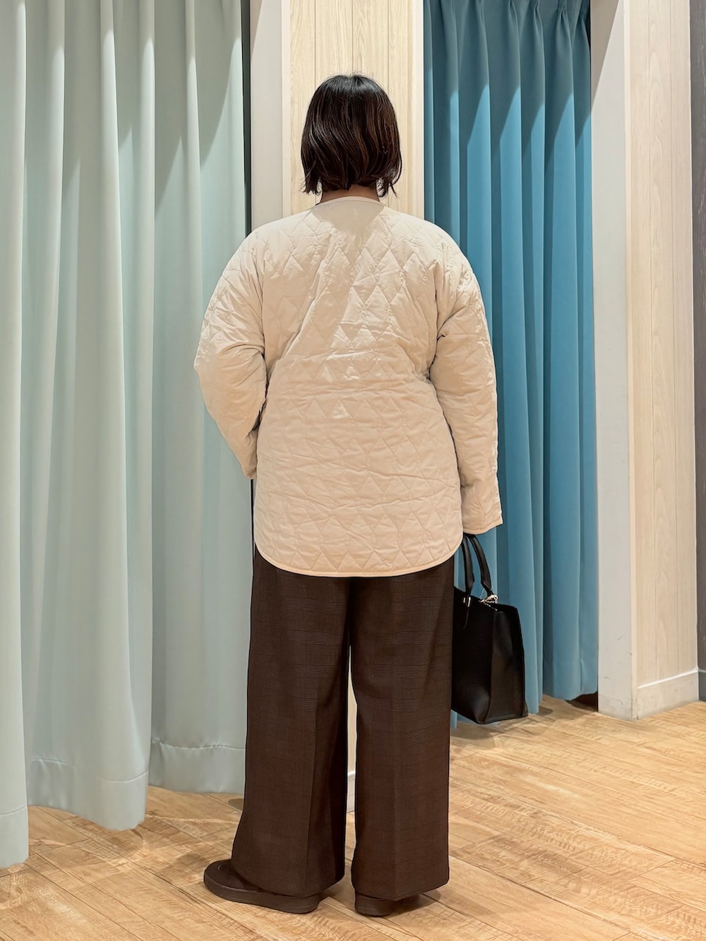 ホワイト系のノーカラージャケット、グレー系のニット/セーター、ブラウン系のその他パンツを着用したレディースの秋コーディネートの3枚目の写真