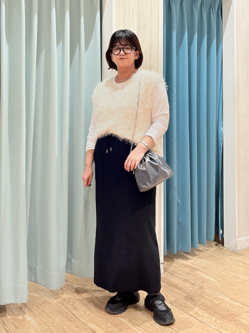 ベージュ系のニット/セーター、ブラック系のスカート、グレー系のショルダーバッグを着用したレディースの秋コーディネートの4枚目の写真