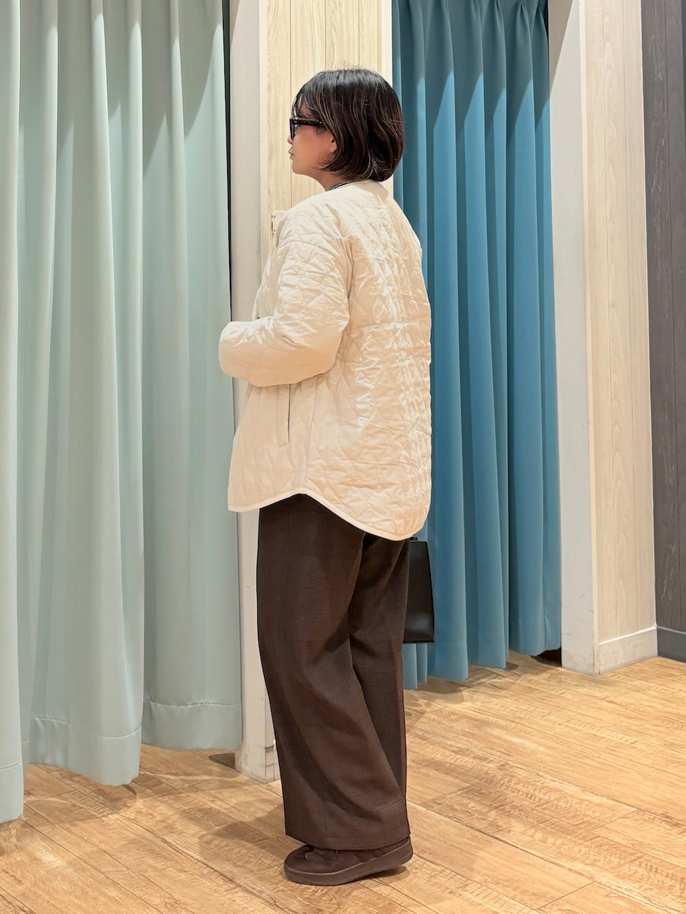 ホワイト系のノーカラージャケット、グレー系のニット/セーター、ブラウン系のその他パンツを着用したレディースの秋コーディネートの5枚目の写真