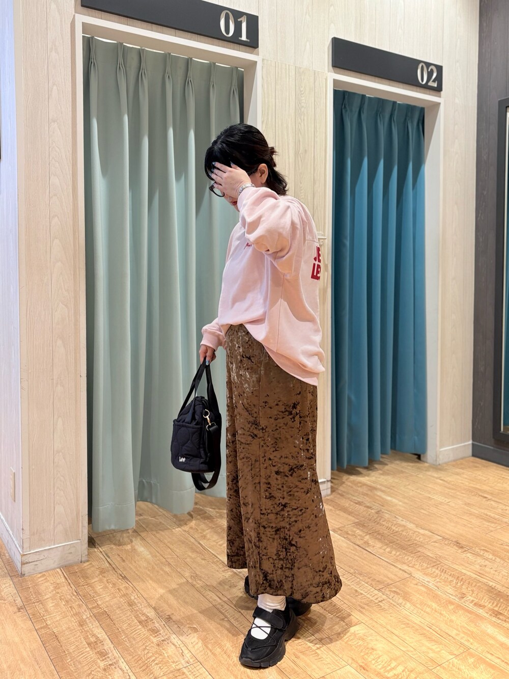 ピンク系のスウェット、ブラウン系のスカート、ブラック系のショルダーバッグを着用したレディースの秋コーディネートの7枚目の写真