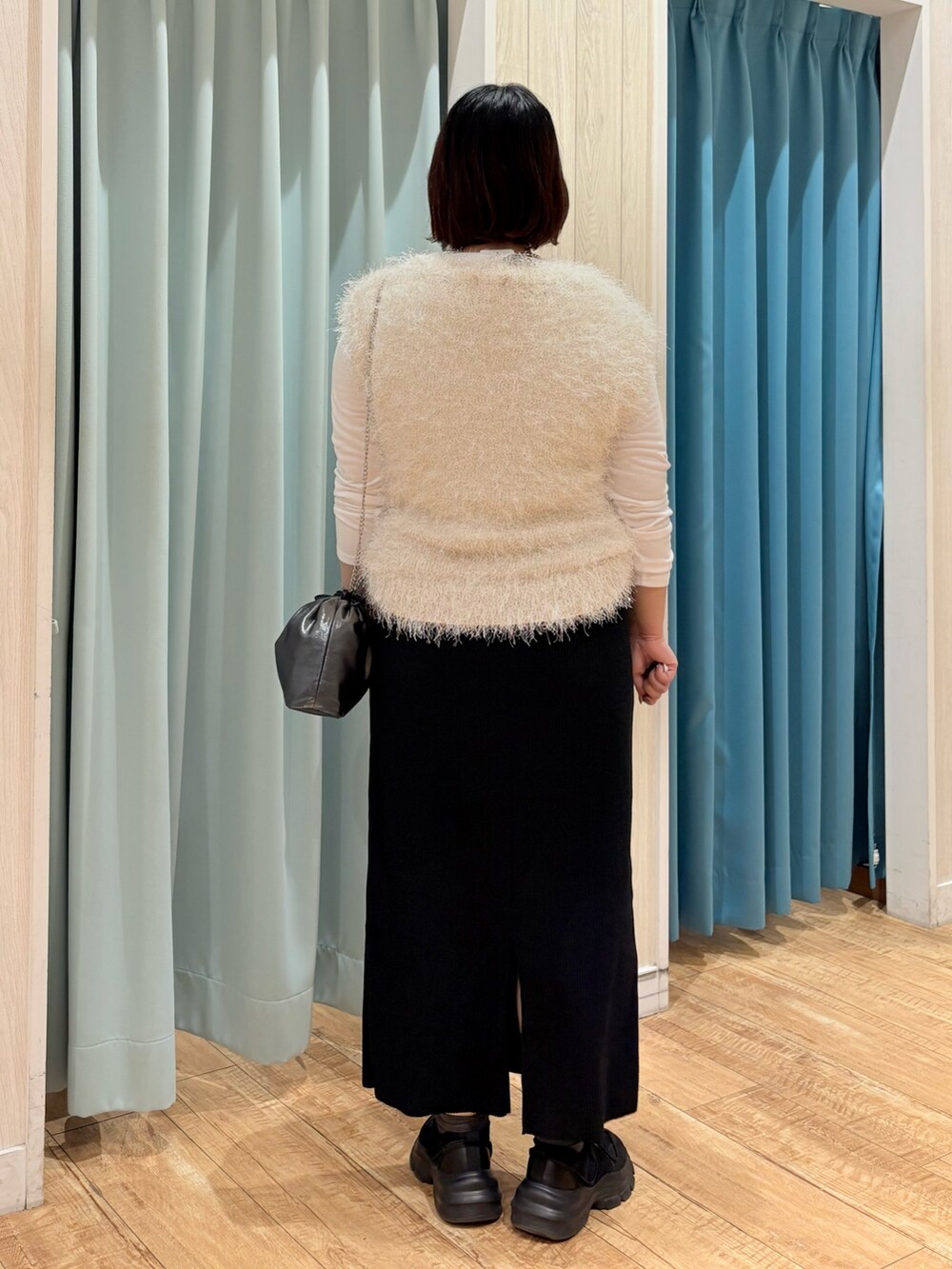 ベージュ系のニット/セーター、ブラック系のスカート、グレー系のショルダーバッグを着用したレディースの秋コーディネートの3枚目の写真