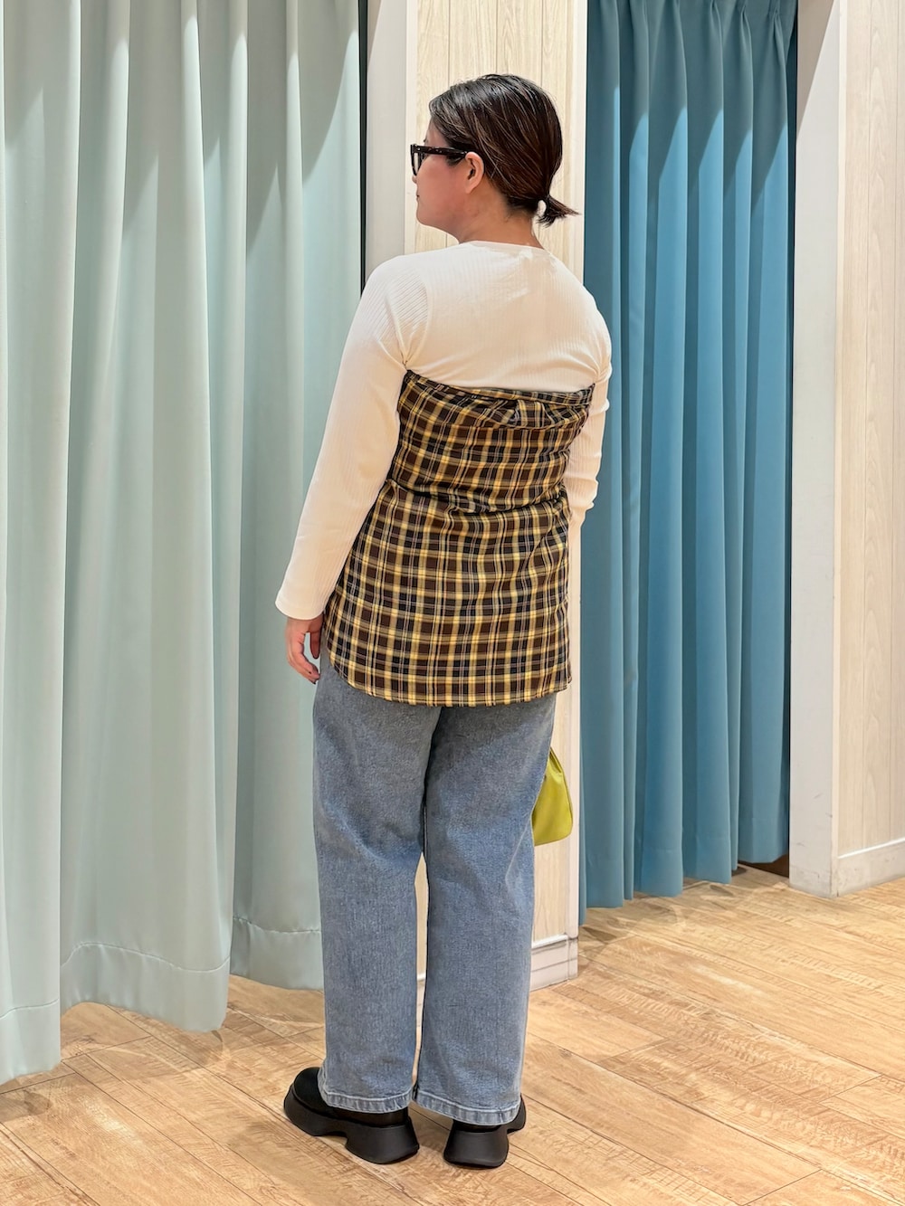 イエロー系のシャツ/ブラウス、ホワイト系のTシャツ/カットソー、ブルー系のデニムパンツを着用したレディースの秋コーディネートの3枚目の写真