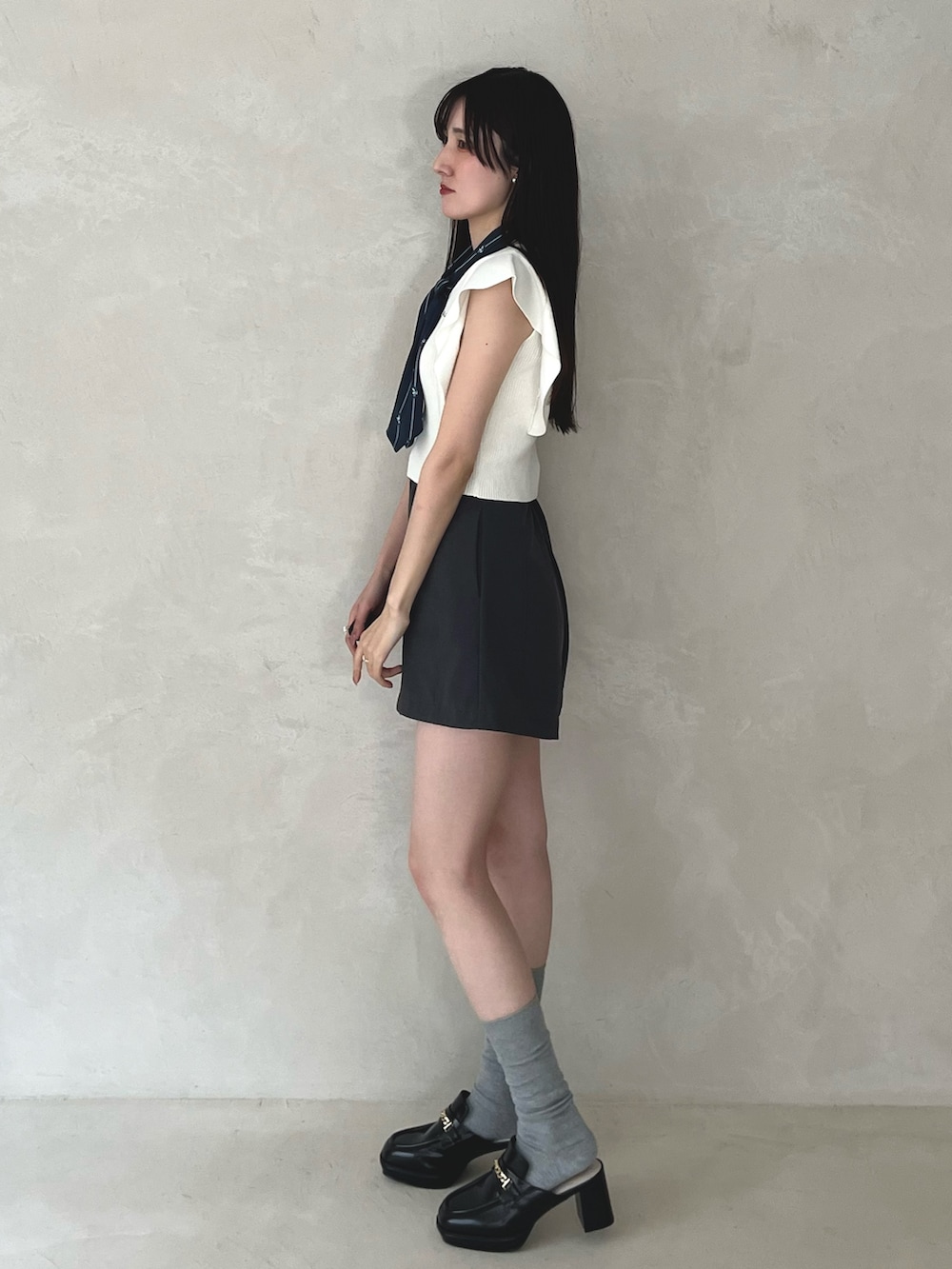 グレー系のその他パンツ、ブラック系のシューズ、ホワイト系のニット/セーターを着用したレディースの夏コーディネートの4枚目の写真