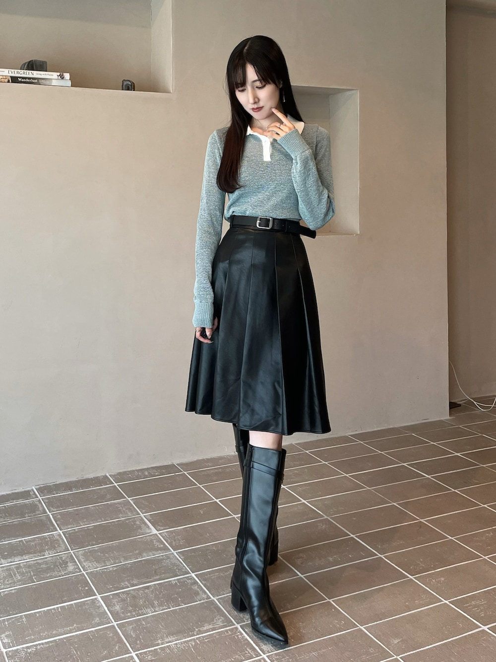 ブラック系のブーツ、ブラック系のスカート、ブルー系のニット/セーターを着用したレディースの秋コーディネートの2枚目の写真