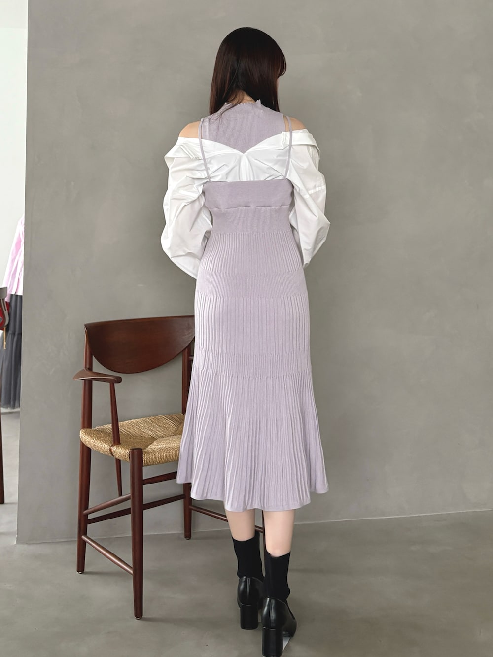 パープル系のワンピース、ブラック系のショルダーバッグ、グレー系のブーツを着用したレディースの冬コーディネートの4枚目の写真