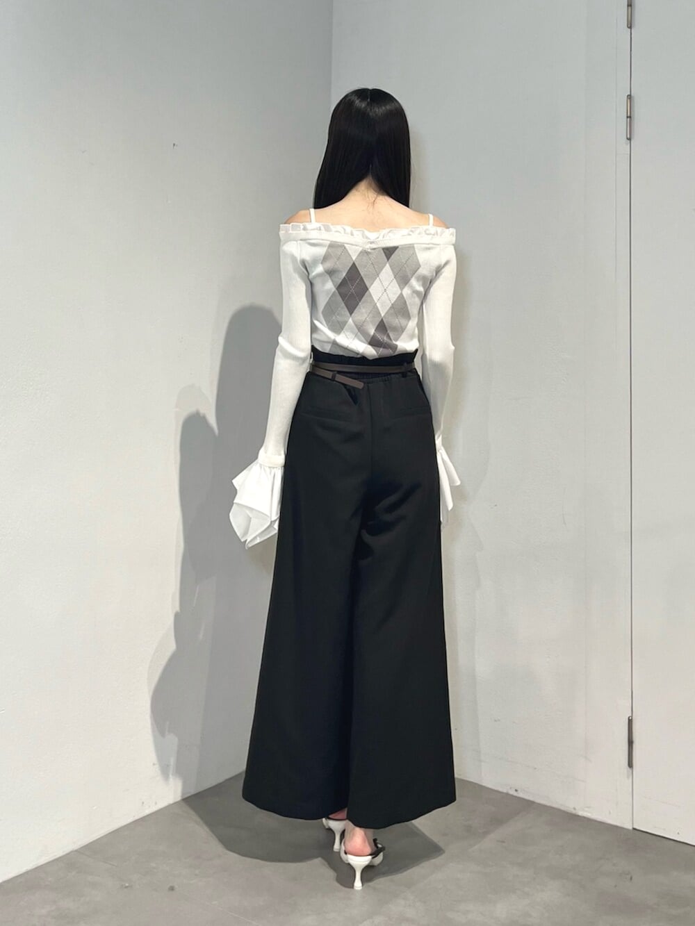 ブラック系のその他パンツ、ホワイト系のサンダル、ホワイト系のニット/セーターを着用したレディースの秋コーディネートの4枚目の写真