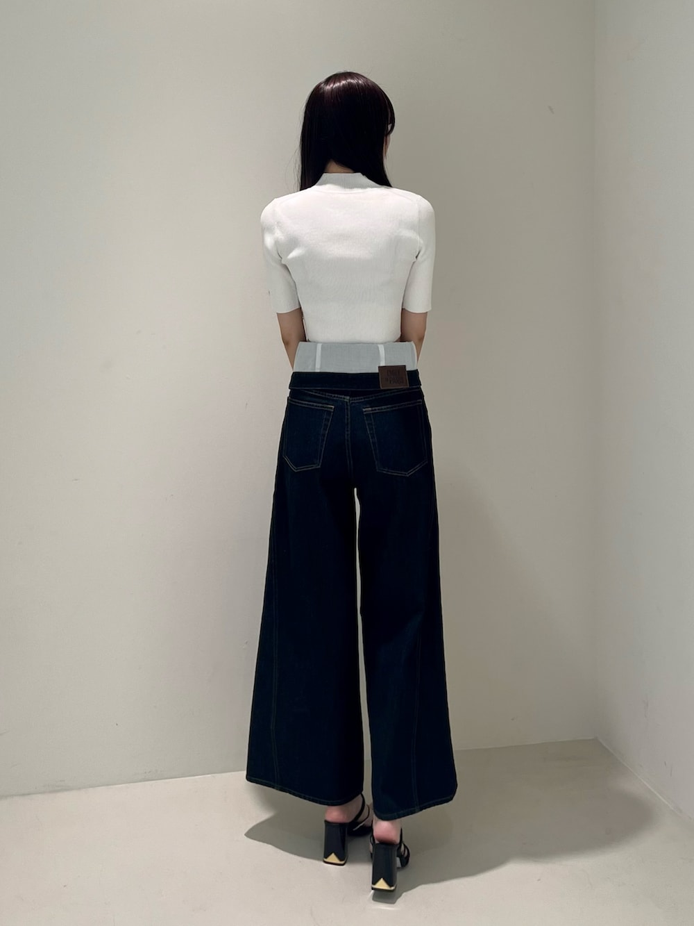 ホワイト系のニット/セーター、ブルー系のその他パンツ、ブラック系のサンダルを着用したレディースの春コーディネートの4枚目の写真