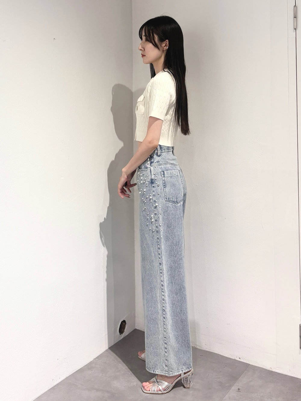 ブルー系のデニムパンツ、シルバー系のサンダル、ホワイト系のカーディガン/ボレロを着用したレディースの夏コーディネートの3枚目の写真