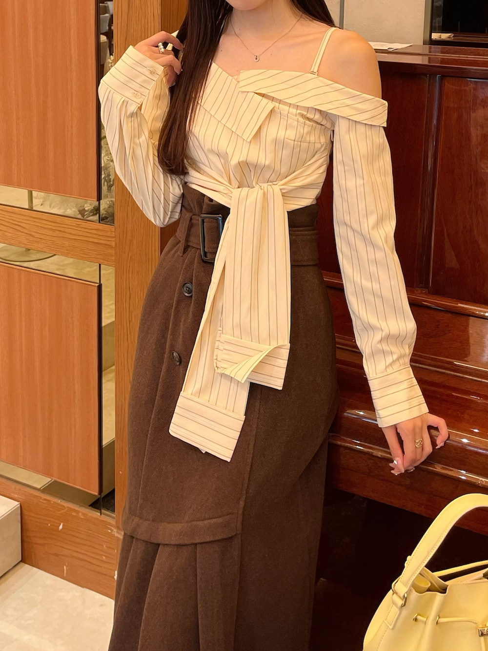 ブラウン系のブーツ、ブラウン系のスカート、イエロー系のショルダーバッグを着用したレディースの冬コーディネートの5枚目の写真