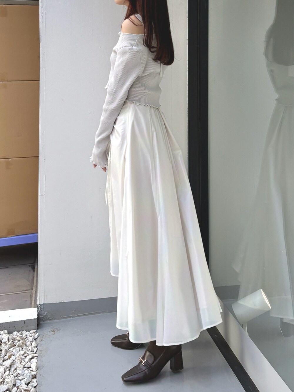 グレー系のカーディガン/ボレロ、グレー系のニット/セーター、ホワイト系のスカートを着用したレディースの冬コーディネートの3枚目の写真