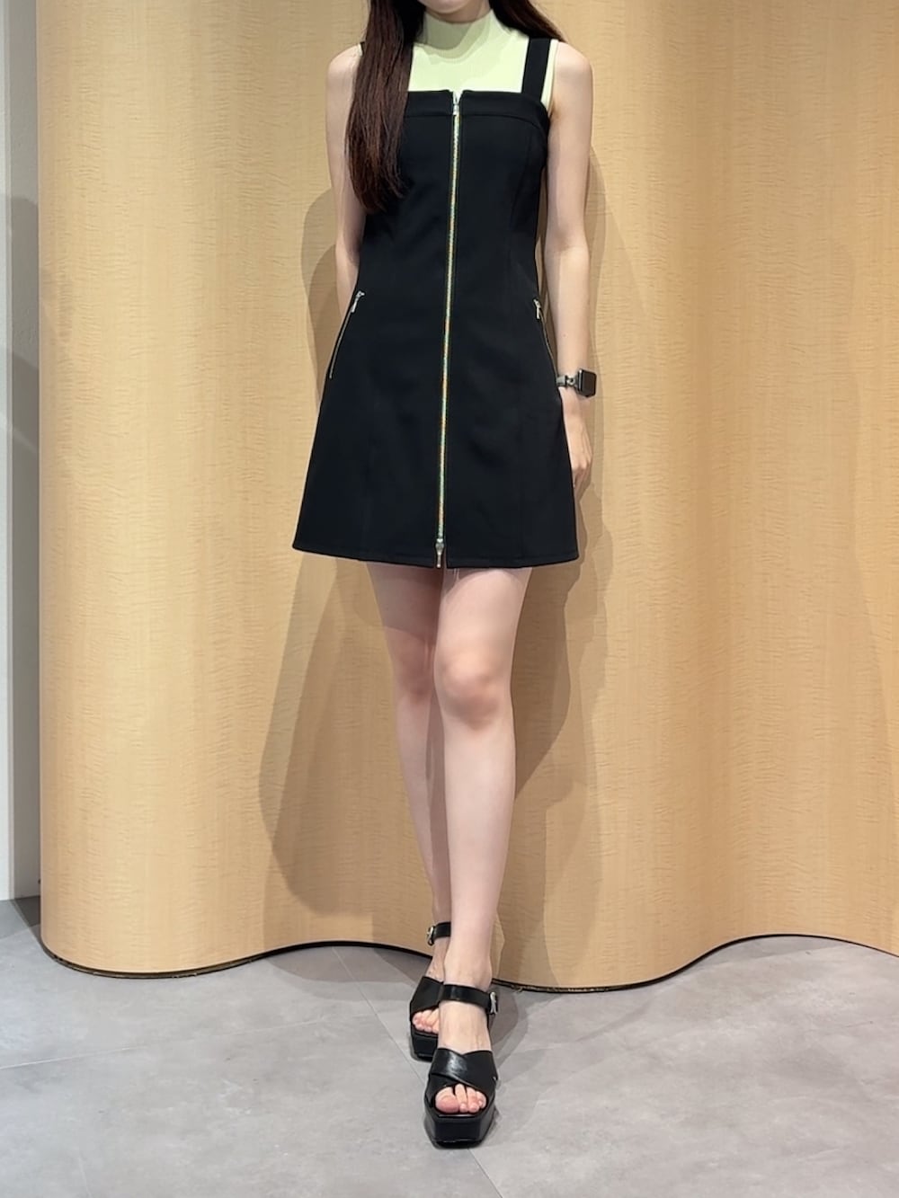 ブラック系のワンピース、イエロー系のニット/セーター、ブラック系のサンダルを着用したレディースの夏コーディネートの2枚目の写真