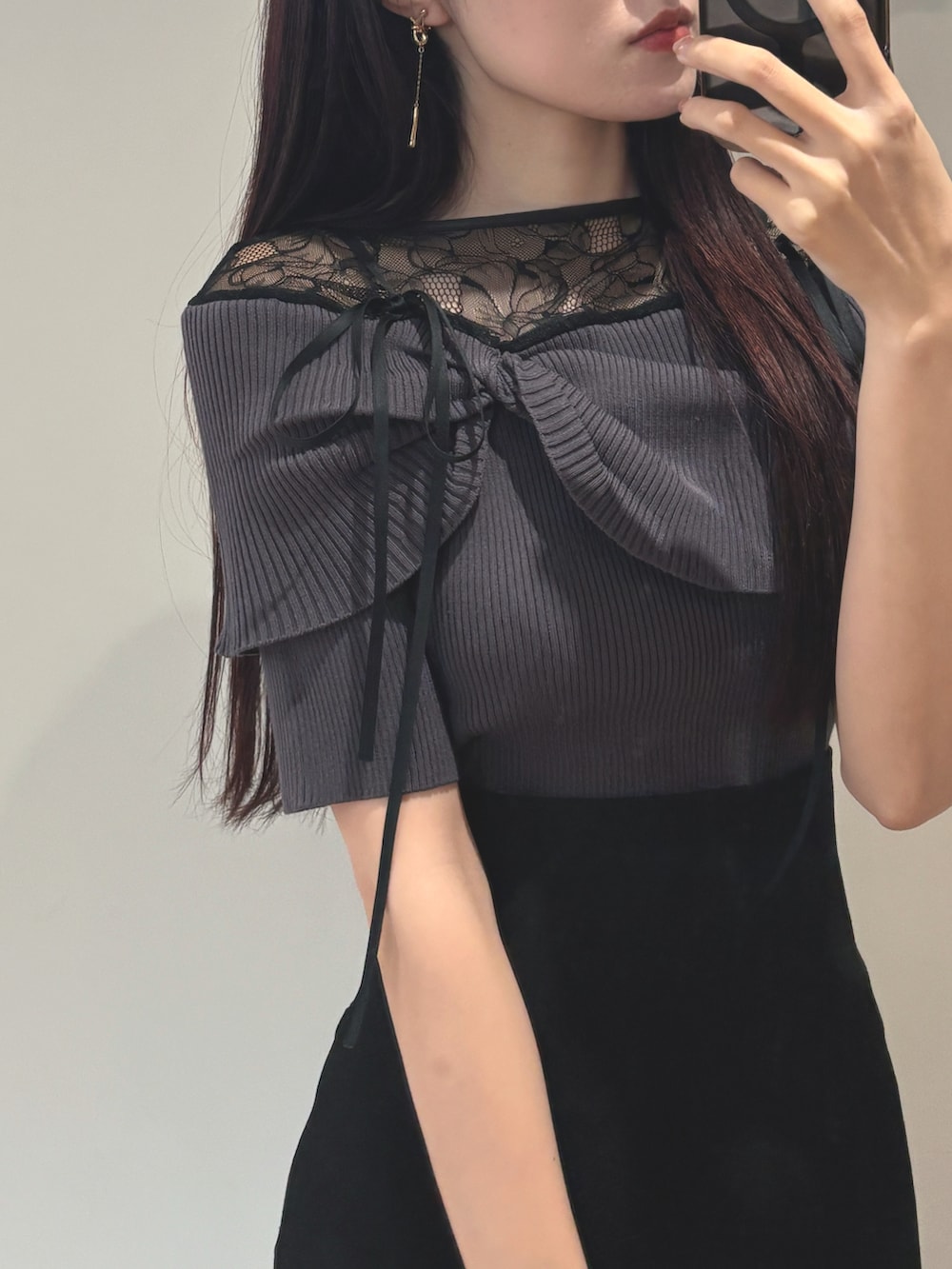 ブラック系のスカート、ブラック系のパンプス、グレー系のニット/セーターを着用したレディースの春コーディネートの3枚目の写真