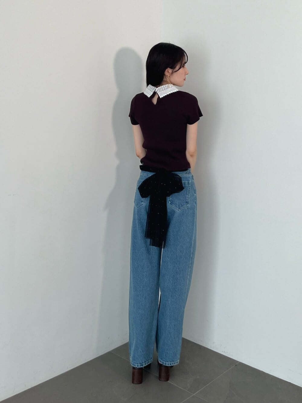 ブラウン系のニット/セーター、ブラウン系のローファー、ブルー系のデニムパンツを着用したレディースの夏コーディネートの8枚目の写真