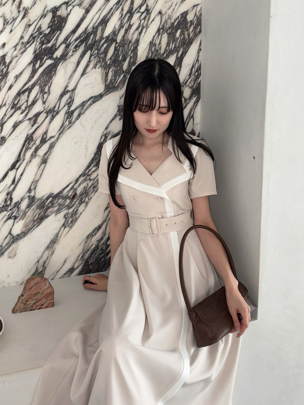 ベージュ系のワンピース、ブラウン系のハンドバッグ、ブラウン系のパンプスを着用したレディースの春コーディネートの5枚目の写真