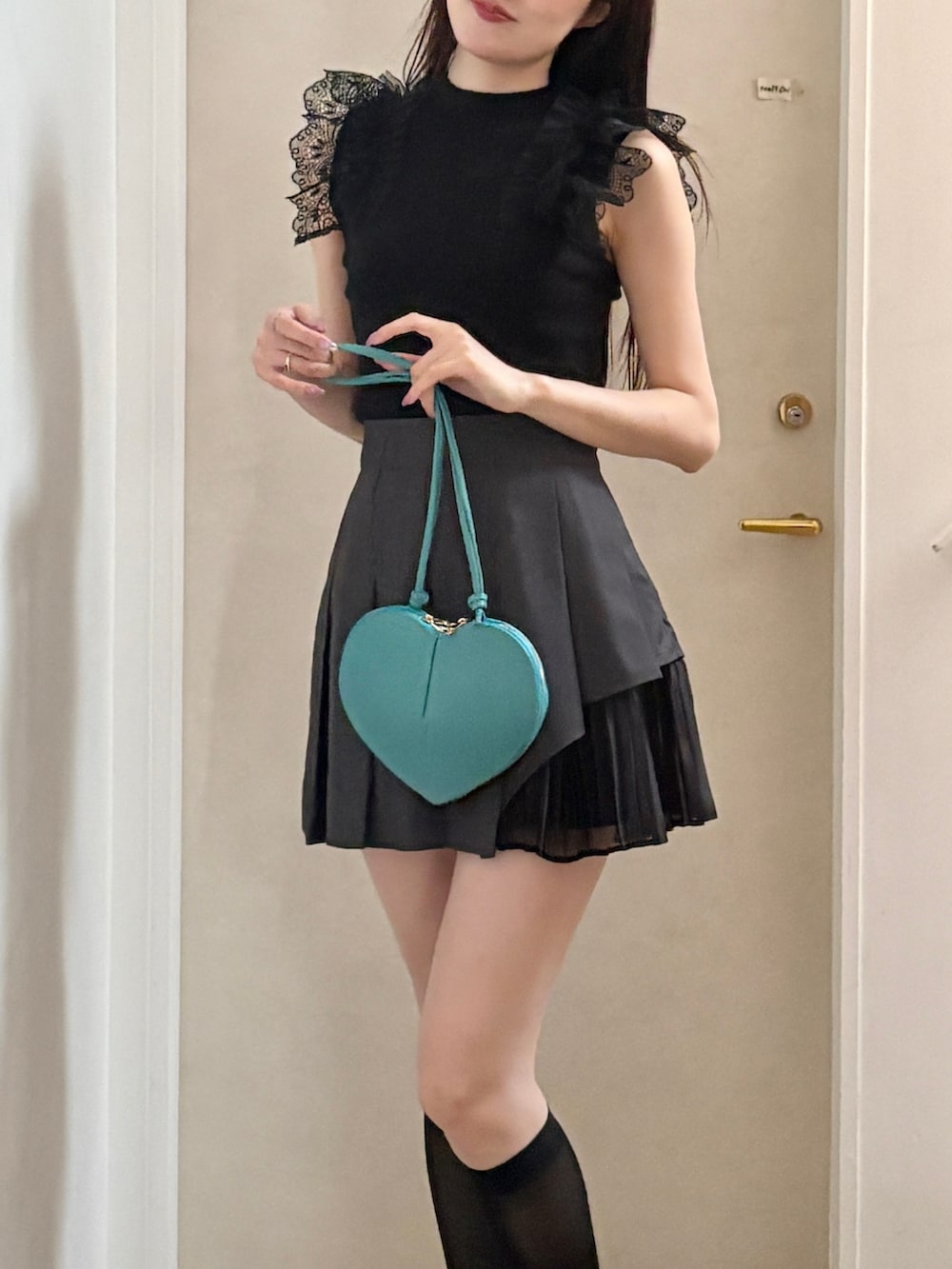 ブラック系のパンプス、グレー系のスカート、ブラック系のニット/セーターを着用したレディースの春コーディネートの5枚目の写真