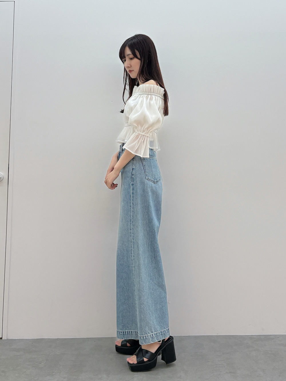 ホワイト系のシャツ/ブラウス、ブルー系のデニムパンツ、ブラック系のサンダルを着用したレディースの春コーディネートの3枚目の写真