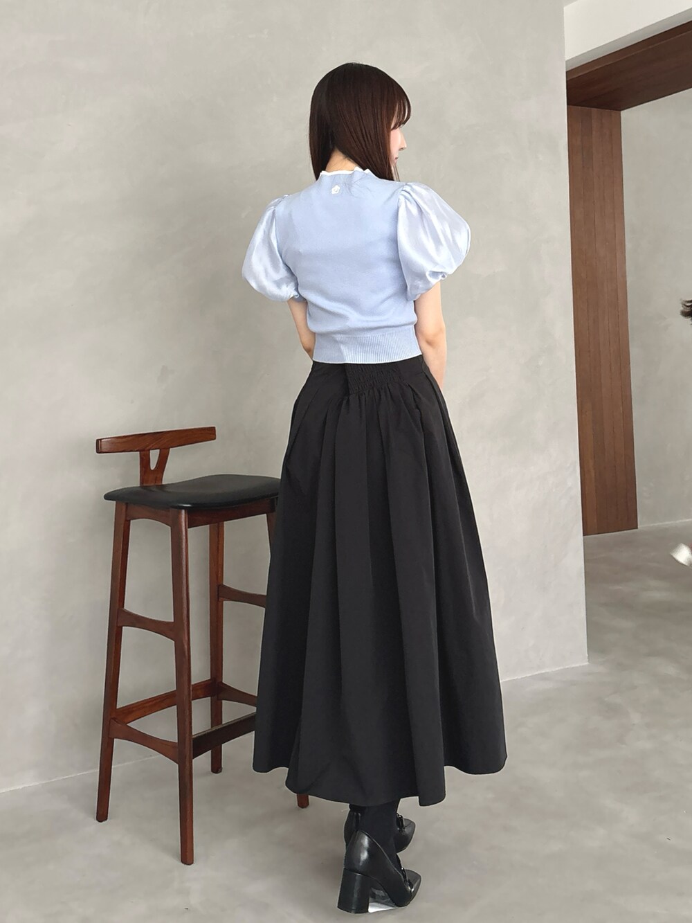 ブルー系のニット/セーター、ブラック系のスカート、ブラウン系のブーツを着用したレディースの冬コーディネートの4枚目の写真