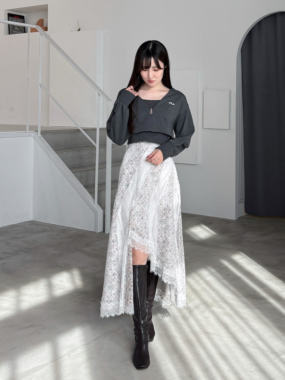 グレー系のTシャツ/カットソー、グリーン系のスカート、ブラウン系のブーツを着用したレディースの冬コーディネートの2枚目の写真