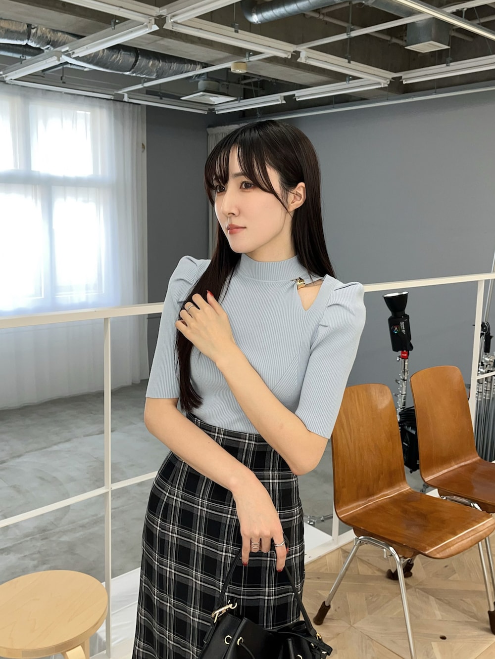 ブラック系のスカート、ブラック系のパンプス、ブルー系のニット/セーターを着用したレディースの春コーディネートの4枚目の写真