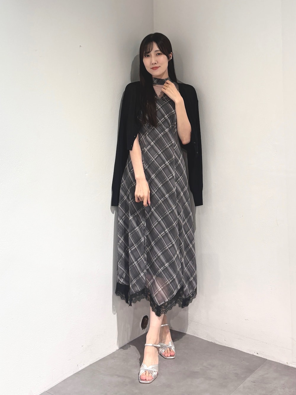 グレー系のワンピース、ブラック系のカーディガン/ボレロ、シルバー系のサンダルを着用したレディースの夏コーディネートの2枚目の写真
