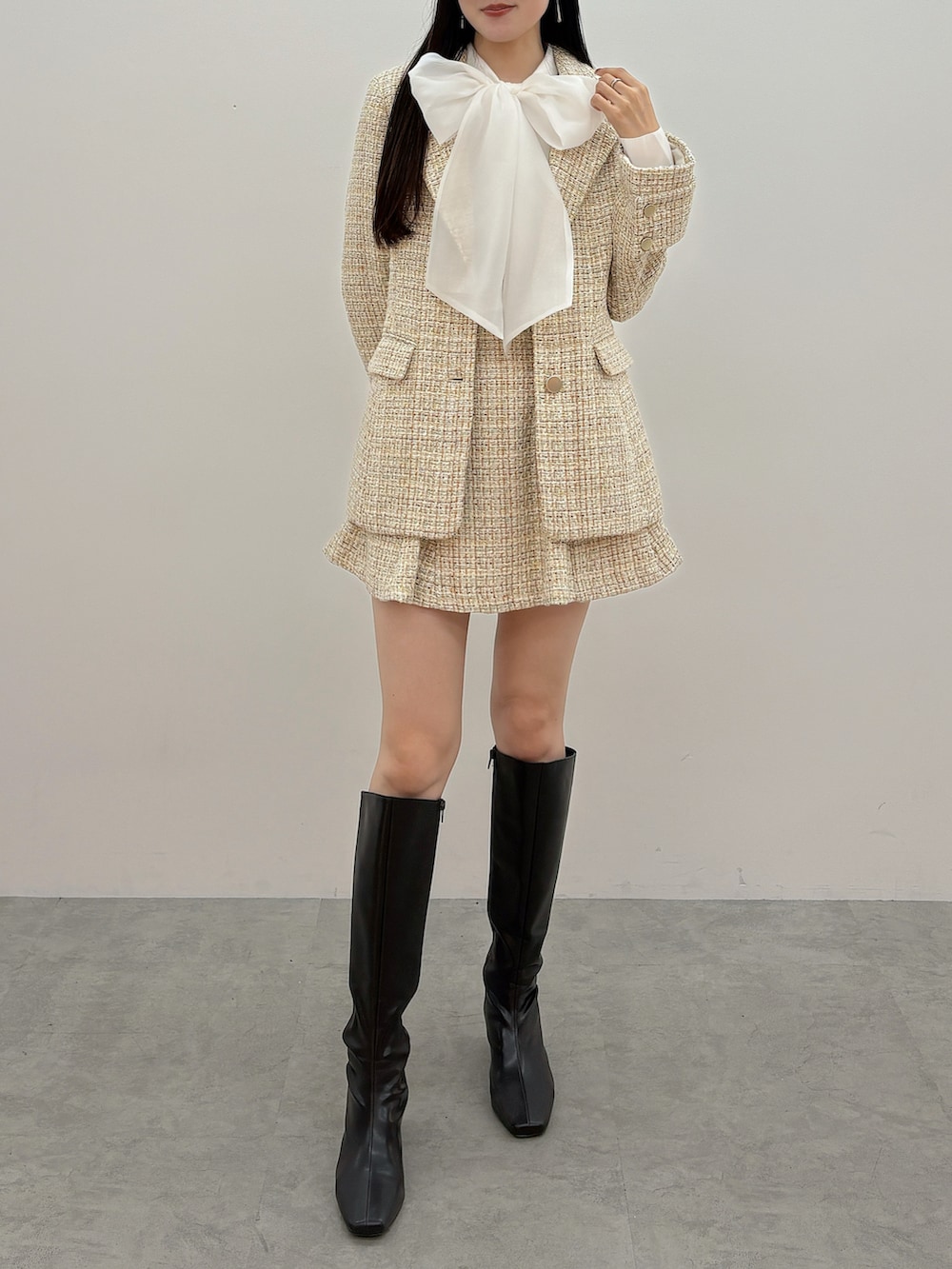 ブラウン系のブーツ、ホワイト系のシャツ/ブラウス、ベージュ系のテーラードジャケットを着用したレディースの冬コーディネートの2枚目の写真