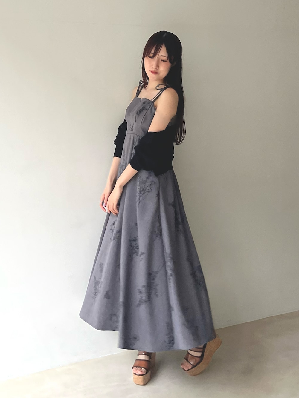 ブラック系のカーディガン/ボレロ、ブラウン系のサンダル、グレー系のワンピースを着用したレディースの春コーディネートの3枚目の写真