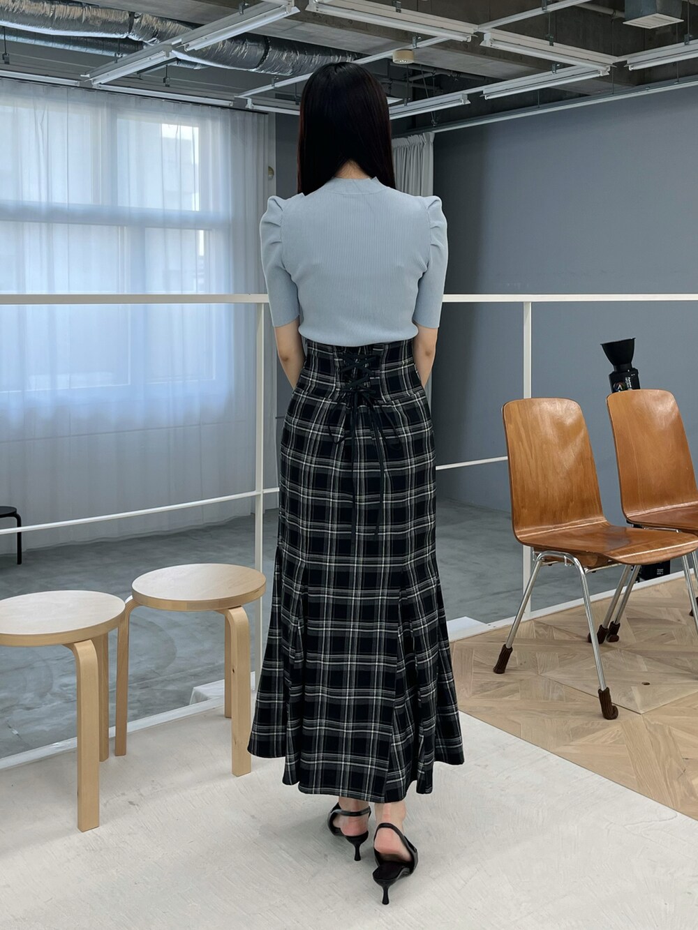 ブラック系のスカート、ブラック系のパンプス、ブルー系のニット/セーターを着用したレディースの春コーディネートの3枚目の写真