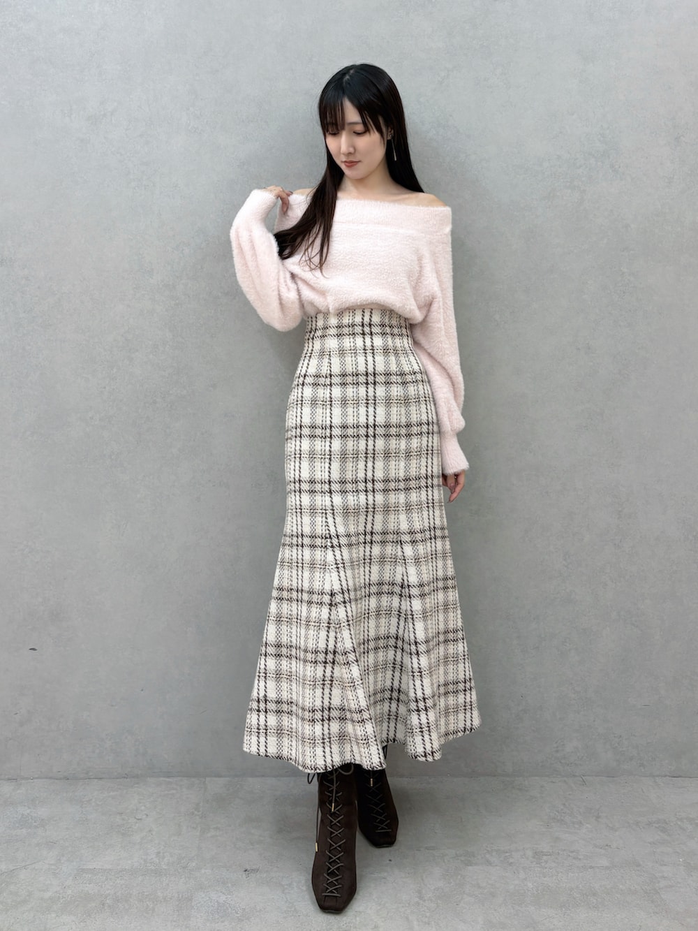 ブラウン系のブーツ、ホワイト系のスカート、ピンク系のニット/セーターを着用したレディースの冬コーディネートの2枚目の写真
