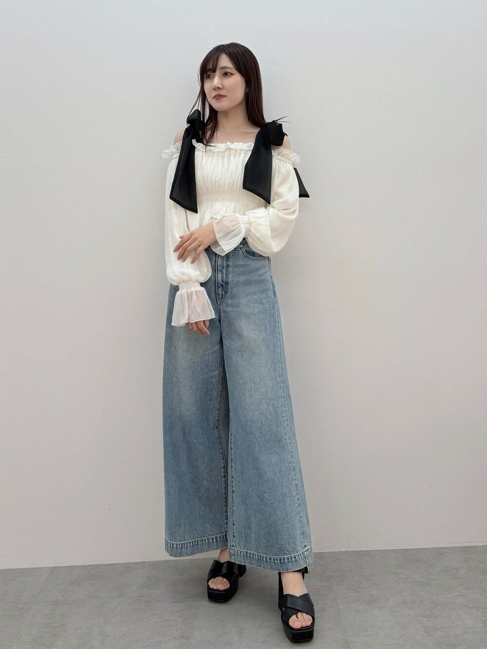 ホワイト系のシャツ/ブラウス、ブルー系のデニムパンツ、ブラック系のサンダルを着用したレディースの春コーディネートの2枚目の写真
