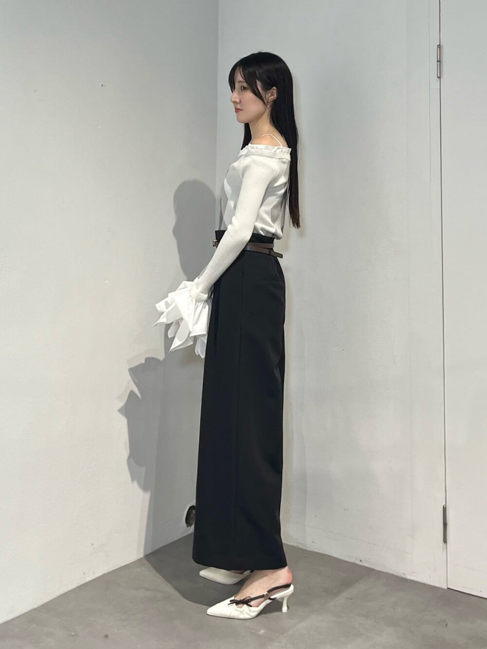 ブラック系のその他パンツ、ホワイト系のサンダル、ホワイト系のニット/セーターを着用したレディースの秋コーディネートの3枚目の写真
