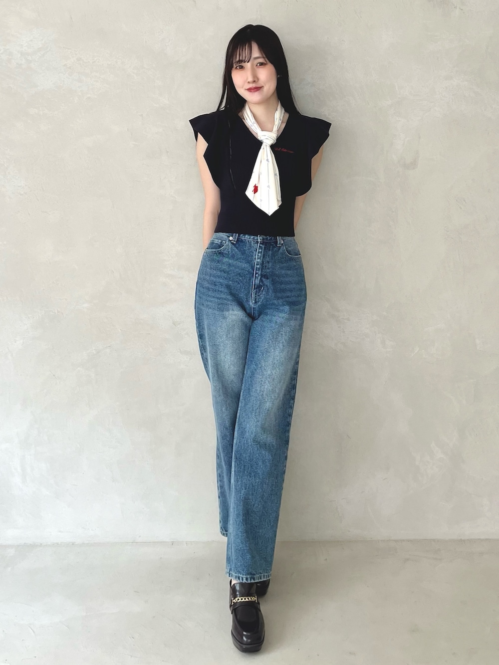 ブルー系のデニムパンツ、ブラウン系のシューズ、ブルー系のニット/セーターを着用したレディースの夏コーディネートの2枚目の写真