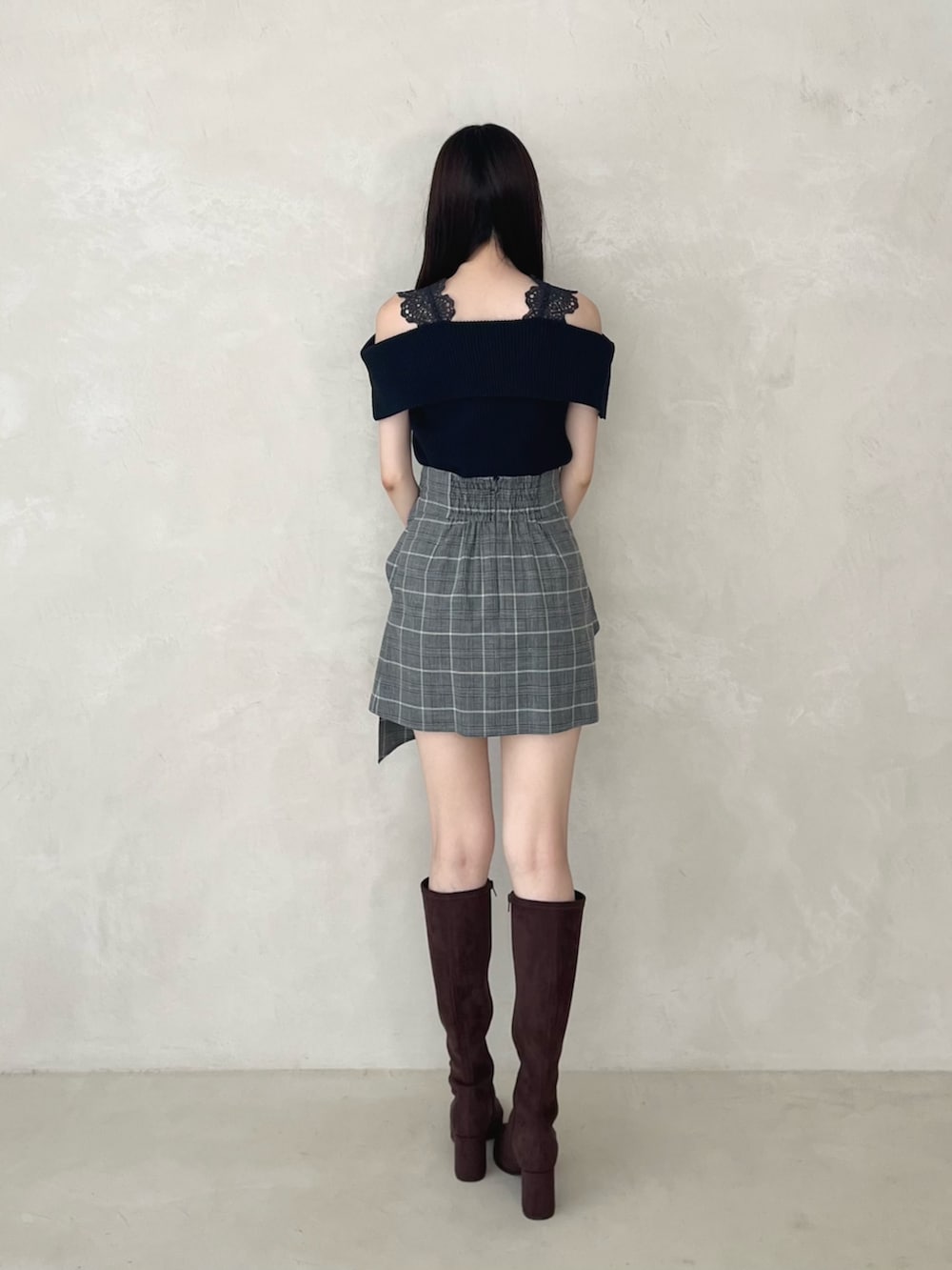 ブラック系のスカート、ブラウン系のブーツ、ブルー系のニット/セーターを着用したレディースの夏コーディネートの4枚目の写真
