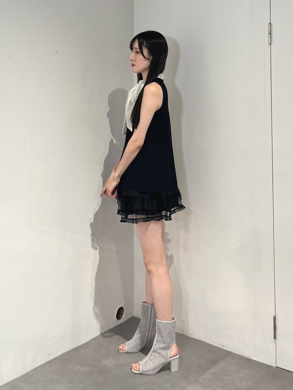 ブラック系のスカート、ブラック系のニット/セーター、グレー系のブーツを着用したレディースの夏コーディネートの3枚目の写真