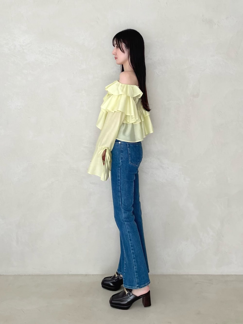 ブルー系のデニムパンツ、ブラウン系のローファー、イエロー系のシャツ/ブラウスを着用したレディースの夏コーディネートの3枚目の写真