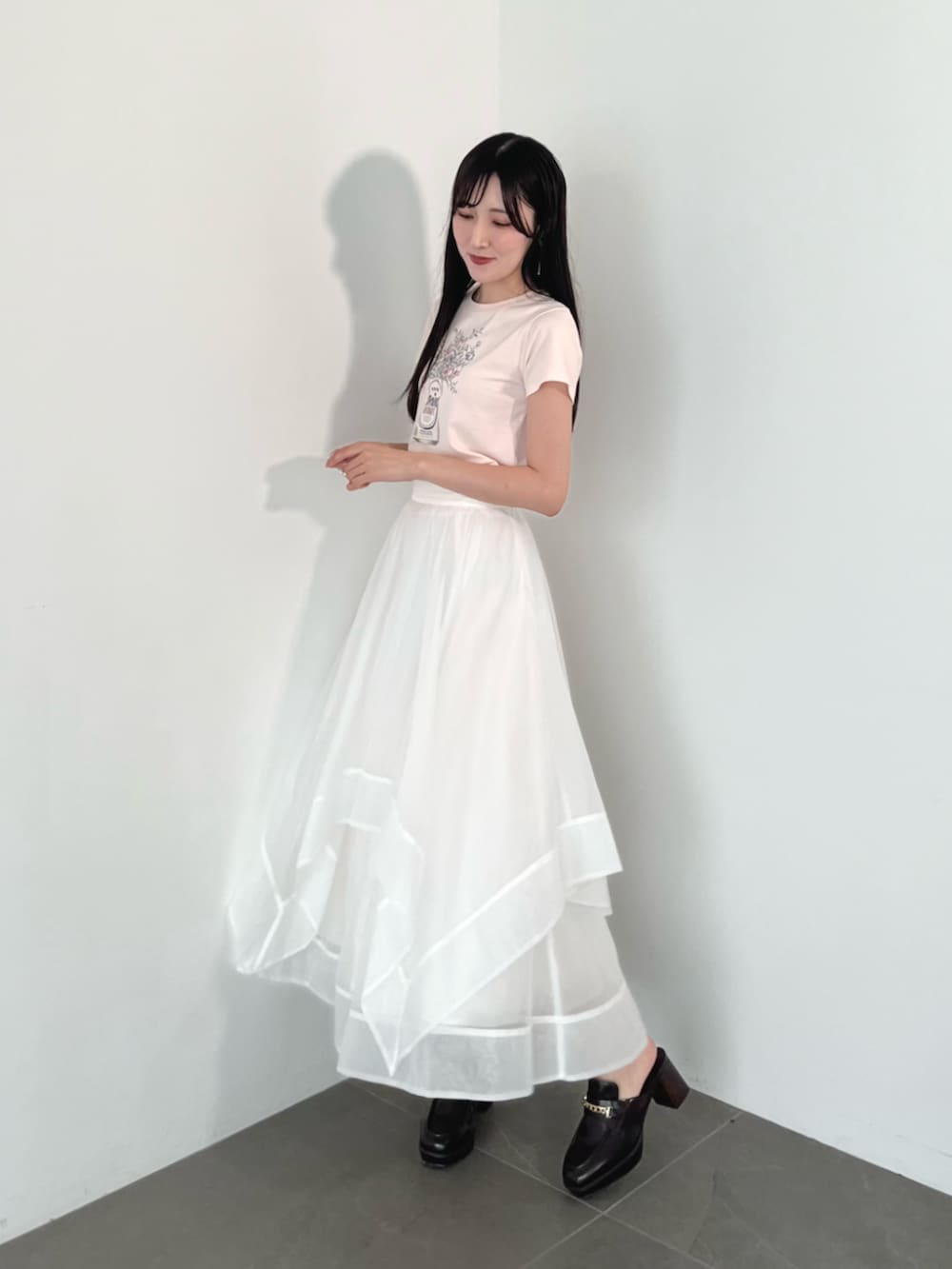 ブラウン系のローファー、ホワイト系のスカートを着用したレディースの夏コーディネートの2枚目の写真