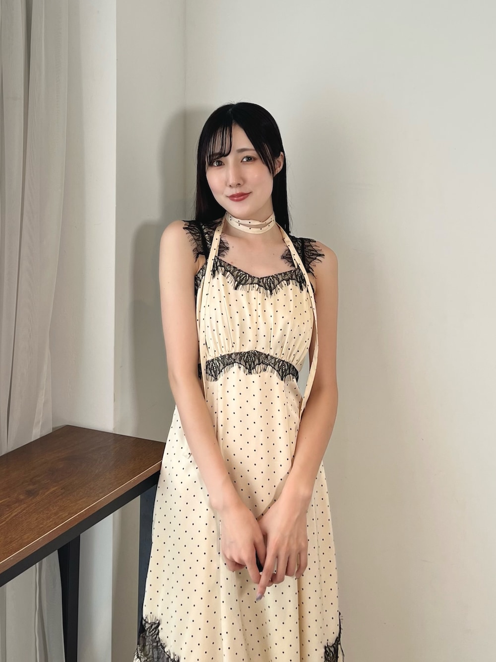 ホワイト系のワンピース、ブラック系のカーディガン/ボレロ、ブラック系のブーツを着用したレディースの秋コーディネートの6枚目の写真