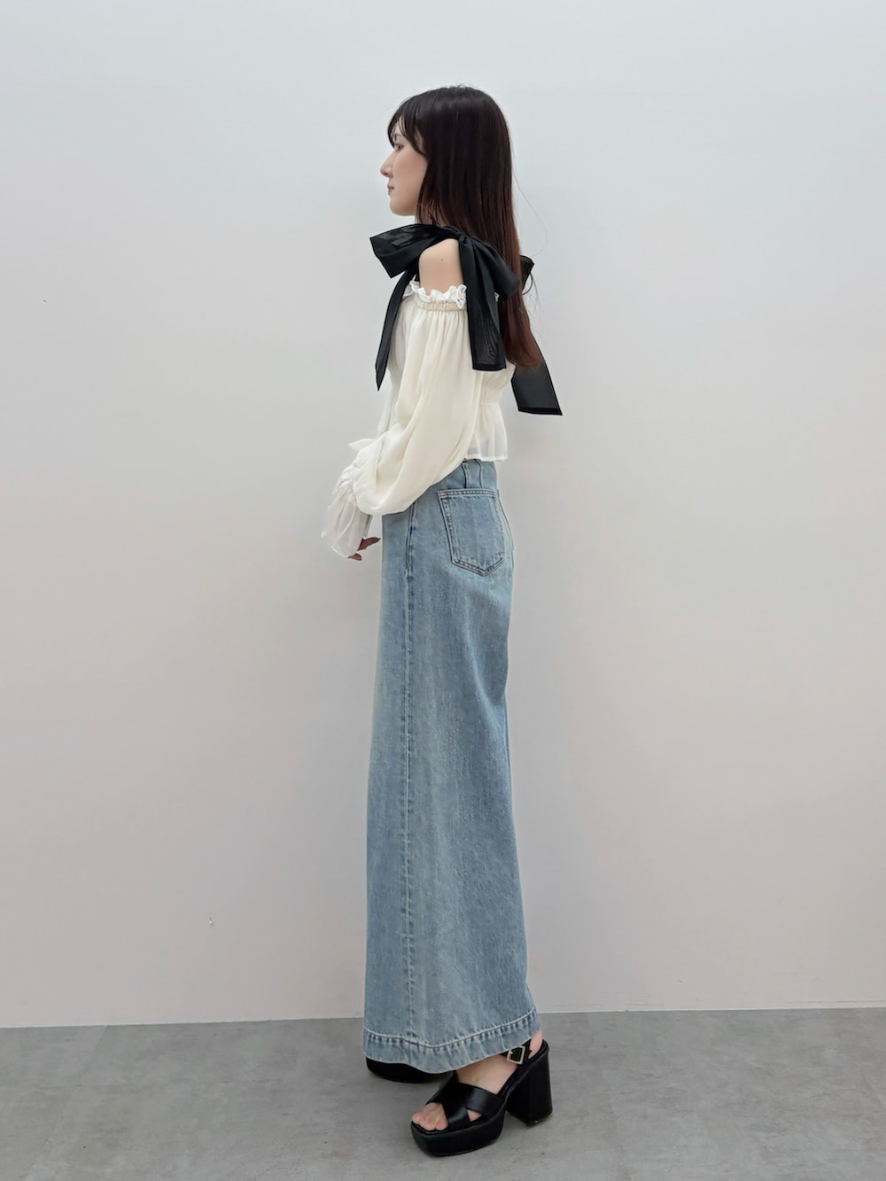 ホワイト系のシャツ/ブラウス、ブルー系のデニムパンツ、ブラック系のサンダルを着用したレディースの春コーディネートの3枚目の写真