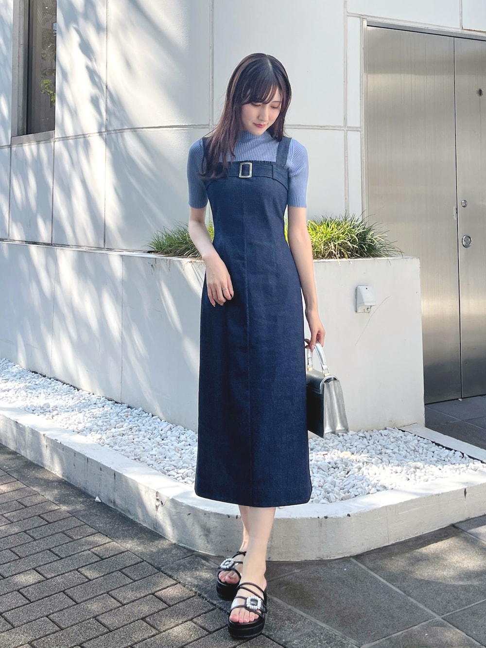 ブルー系のニット/セーター、ブルー系のワンピース、シルバー系のハンドバッグを着用したレディースの秋コーディネートの2枚目の写真