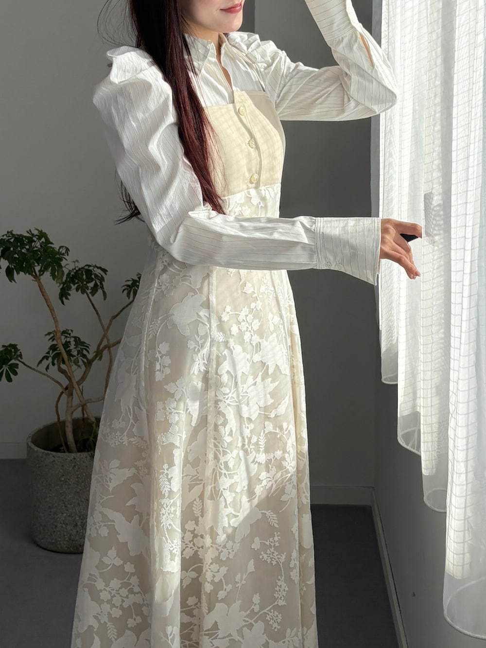 ホワイト系のパンプス、ベージュ系のワンピースを着用したレディースの冬コーディネートの5枚目の写真