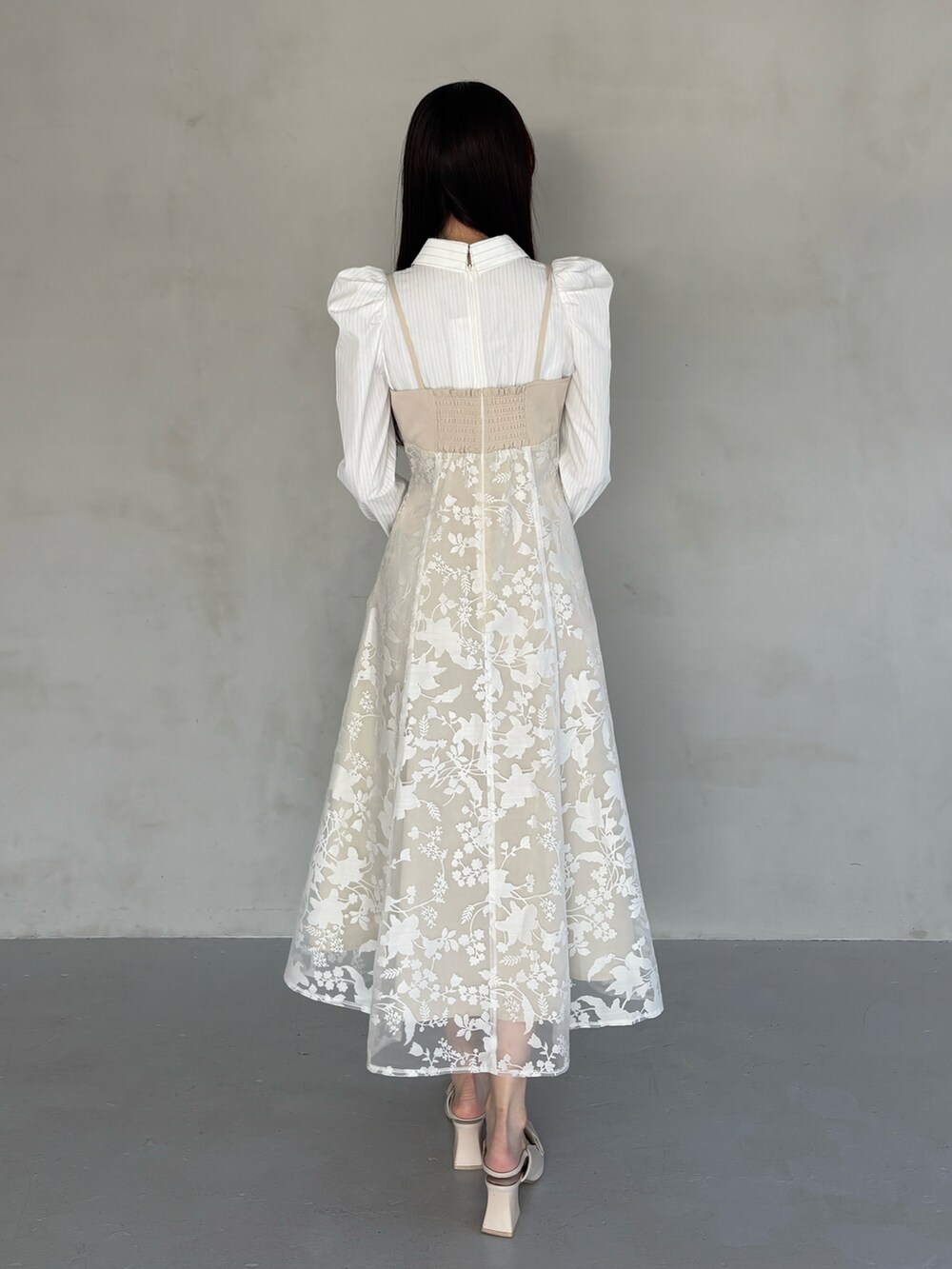 ホワイト系のパンプス、ベージュ系のワンピースを着用したレディースの冬コーディネートの4枚目の写真