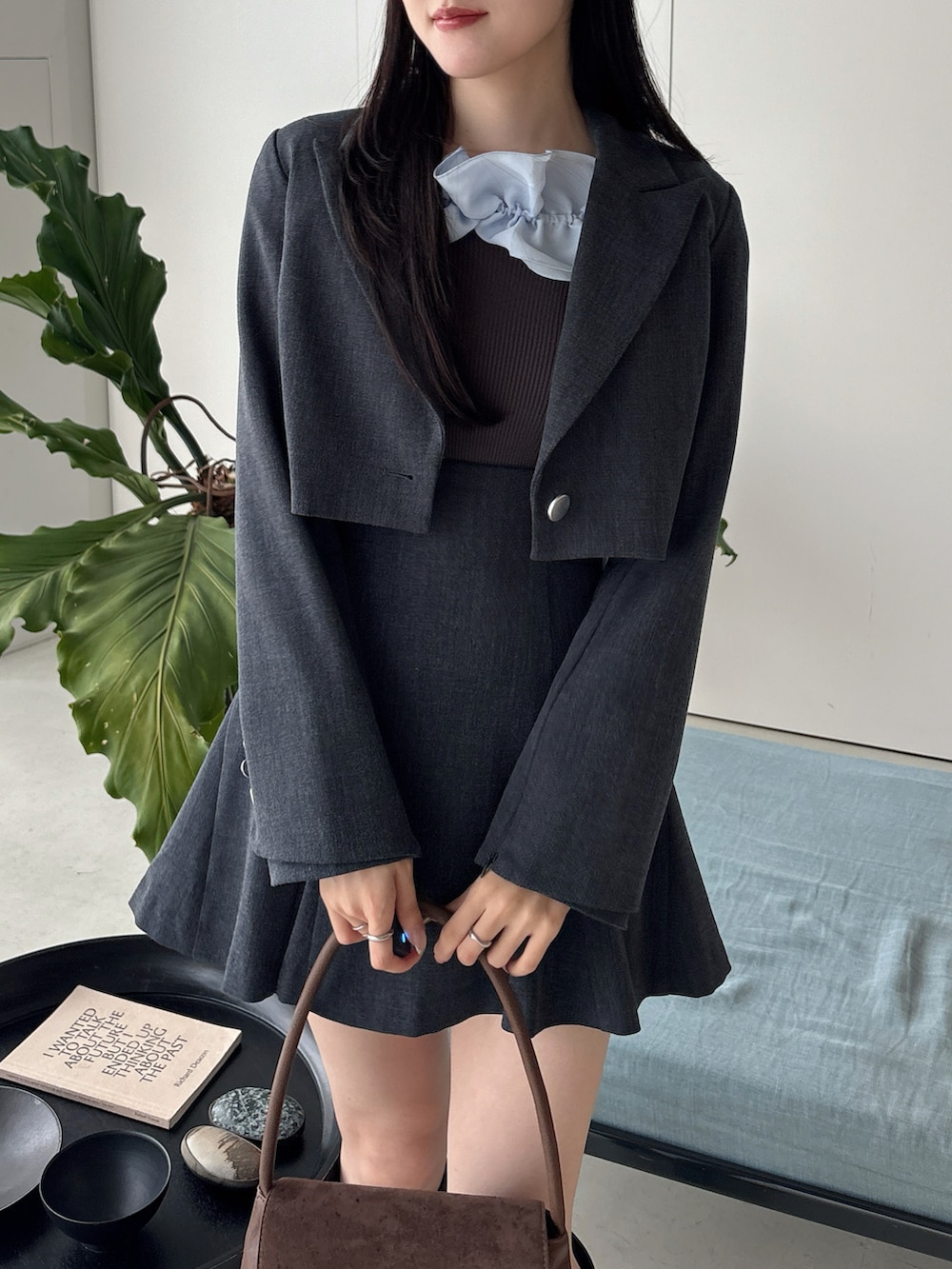 ブラウン系のブーツ、グレー系のテーラードジャケット、グレー系のスカートを着用したレディースの冬コーディネートの5枚目の写真