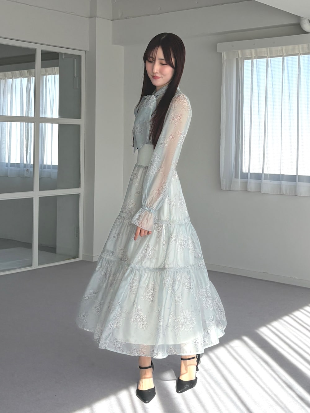 ブラック系のパンプス、グリーン系のワンピースを着用したレディースの春コーディネートの2枚目の写真