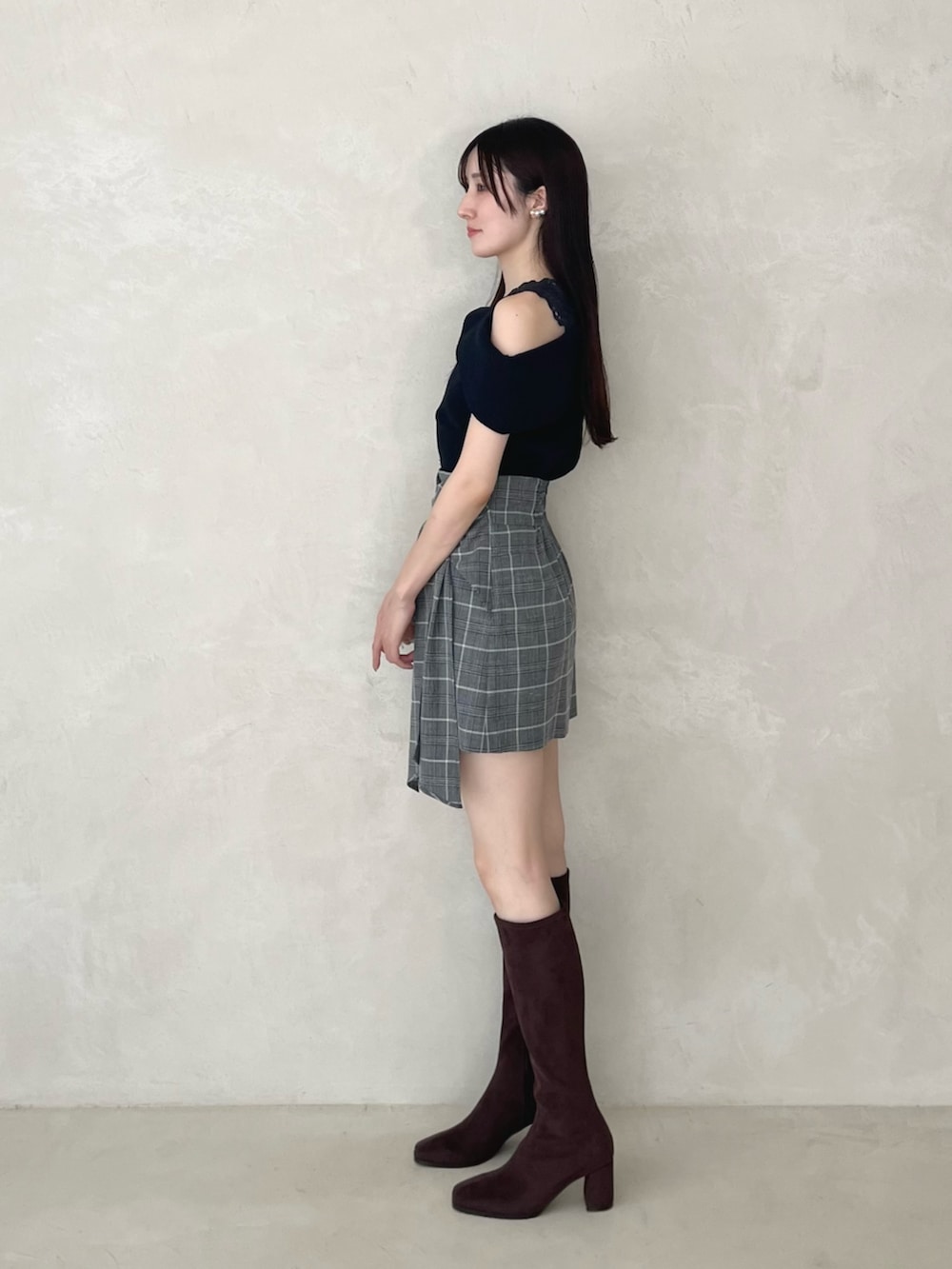 ブラック系のスカート、ブラウン系のブーツ、ブルー系のニット/セーターを着用したレディースの夏コーディネートの3枚目の写真