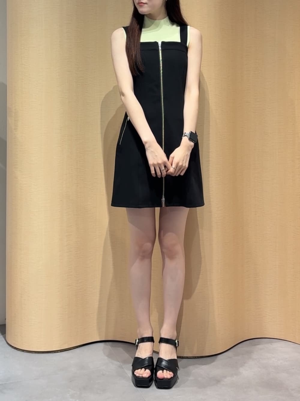 ブラック系のワンピース、イエロー系のニット/セーター、ブラック系のサンダルを着用したレディースの夏コーディネートの3枚目の写真