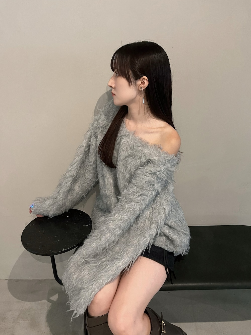 ブラウン系のブーツ、グレー系のニット/セーター、ブラック系のスカートを着用したレディースの冬コーディネートの4枚目の写真