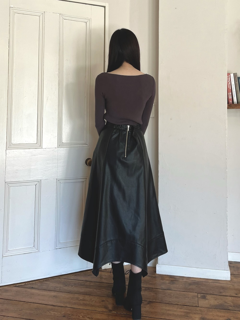 グレー系のニット/セーター、ブラック系のブーツ、ブラック系のショルダーバッグを着用したレディースの秋コーディネートの4枚目の写真