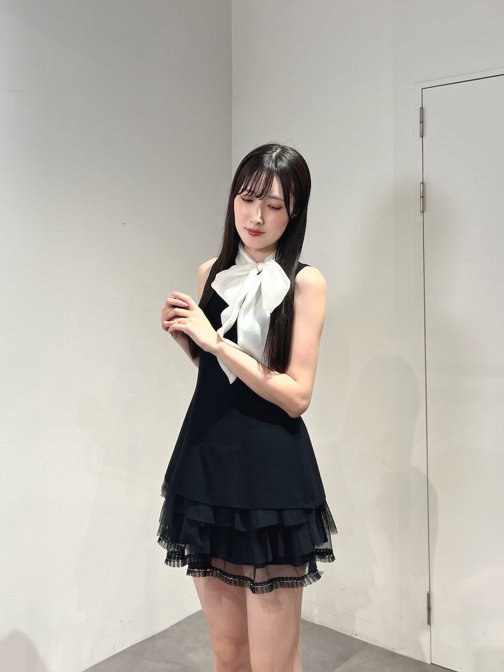 ブラック系のスカート、ブラック系のニット/セーター、グレー系のブーツを着用したレディースの夏コーディネートの6枚目の写真